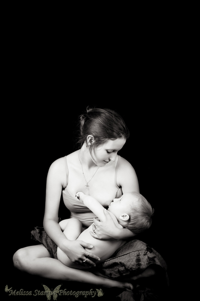 Mother breastfeeding baby black background black and white in studio