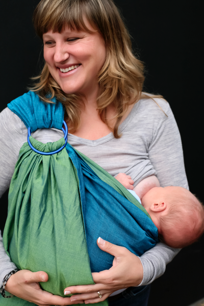 Mother breastfeeding baby in carrier