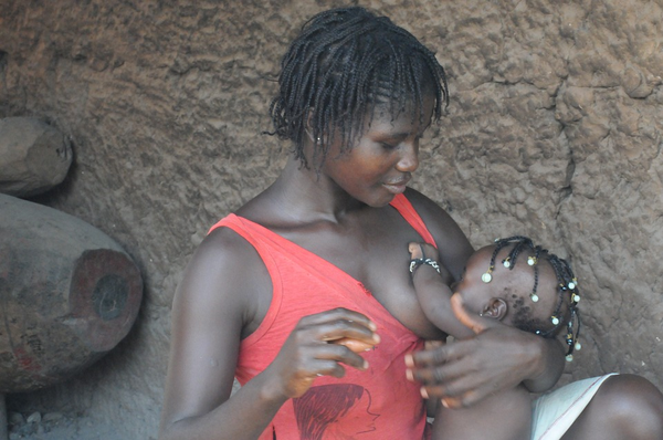 Mother breastfeeding baby in tank top